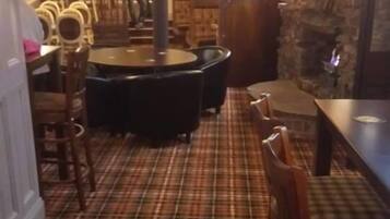 A restaurant with a plaid floor, wooden chairs, and tables.