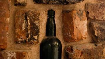 Una botella negra sobre un muro de ladrillo.