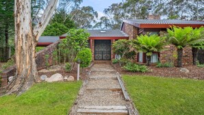A residential property with a brick exterior, a tiled roof, and a gravel pathway leading to a front door. - Rosella Retreat | Perfect getaway for family and friends (Blackheath)