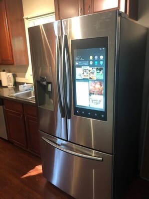 A stainless steel refrigerator with a digital display and a freezer compartment.