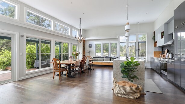 Una cocina amplia con ventanas grandes, un comedor y vistas a zonas verdes.