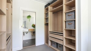 Un vestidor amplio con estanterías abiertas y cajas de almacenamiento.
