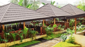 A row of covered outdoor seating areas with wooden railings and lush greenery. - Monty Suites & Golf (Uyo)