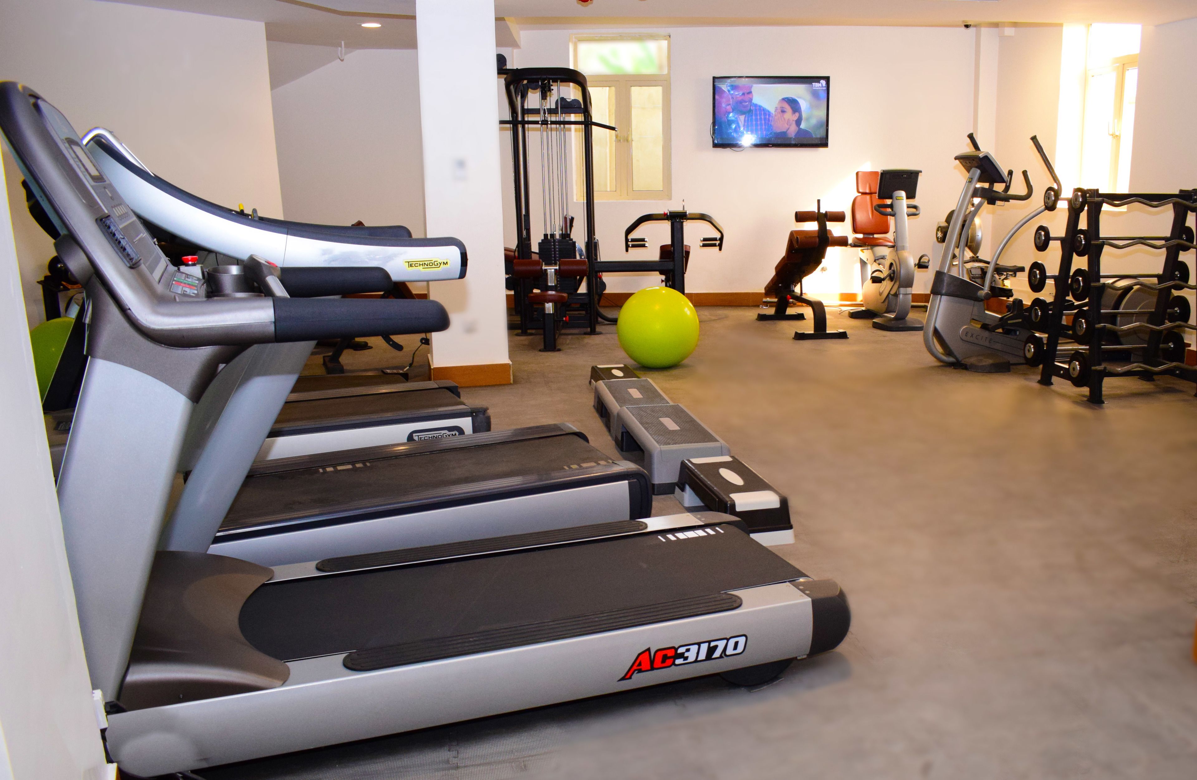 Ein Fitnessstudio mit Laufbändern, Gymbällen und Krafttrainingsgeräten.