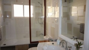 A modern bathroom with a glass-enclosed shower, a toilet, and a sink with a large mirror. - Up-cycle House Blackheath (Blackheath)