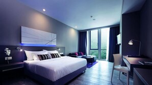 A modern hotel room with a large bed, a desk, and a chair. - Q Stay at Hotel Damansara (Petaling Jaya)