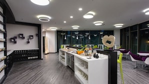 A modern kitchen area with a central island, built-in shelves, and a variety of kitchenware. - Q Stay at Hotel Damansara (Petaling Jaya)