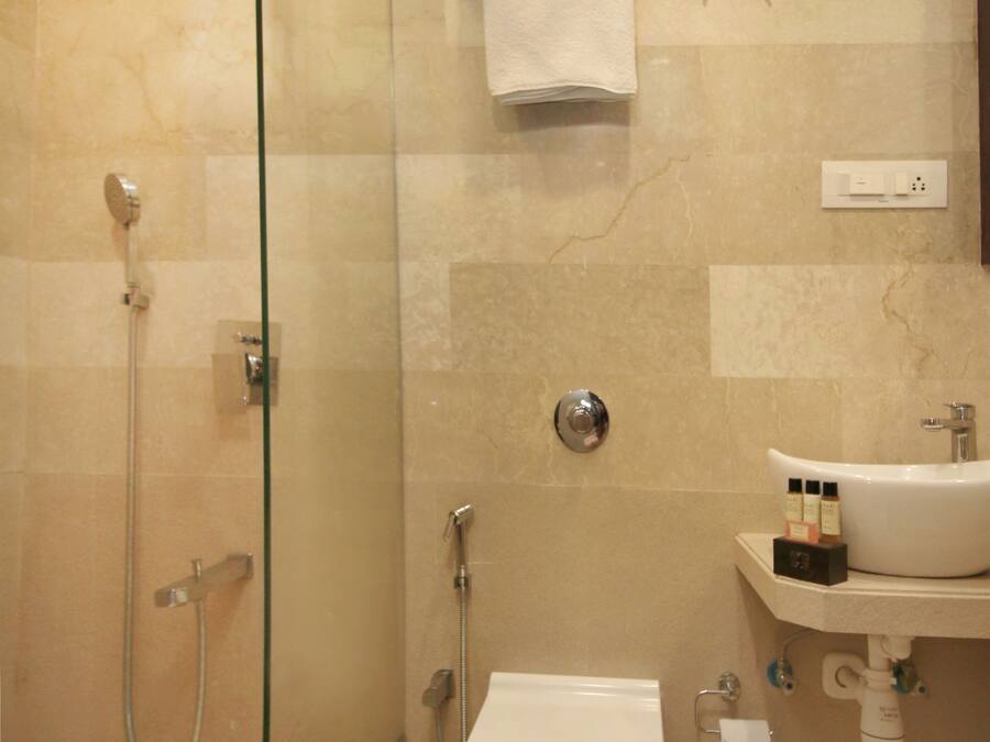 Une salle de bain avec une douche à parois de verre, des toilettes et un lavabo équipé de produits de toilette.