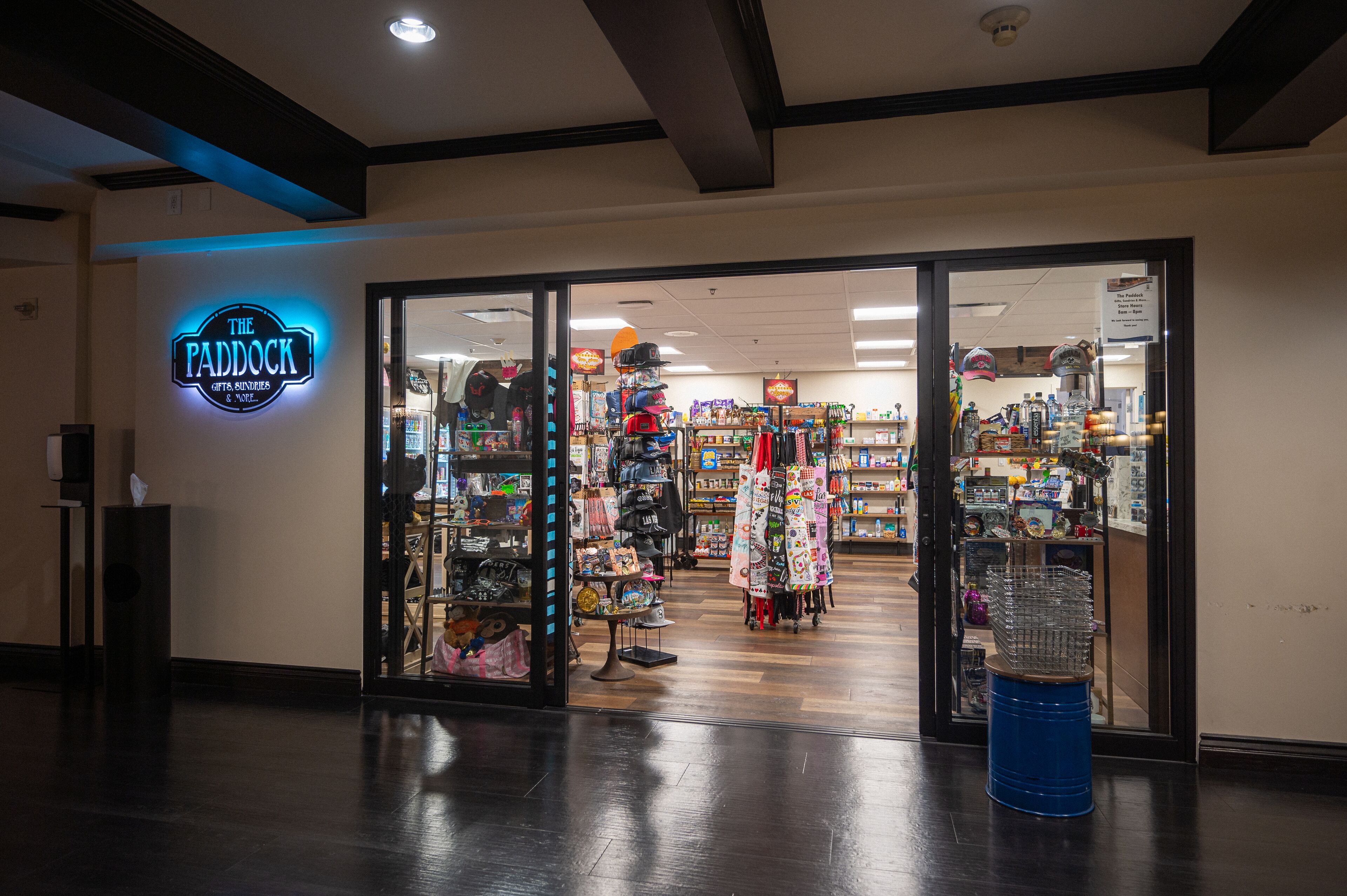 A storefront with a neon sign, glass doors, and various items displayed inside.