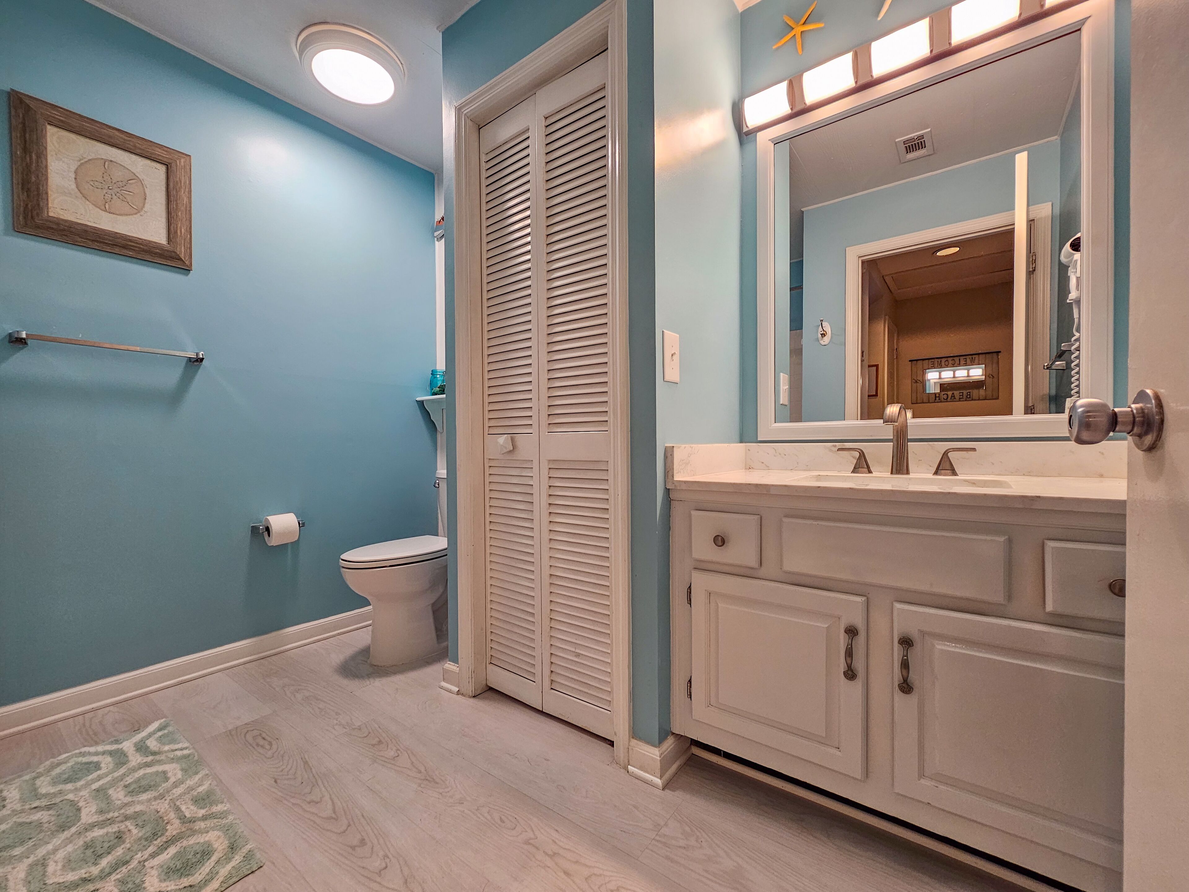 A bathroom with a toilet, a sink, and a mirror.