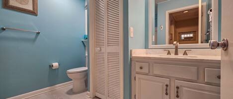 A bathroom with a toilet, a sink, and a mirror.