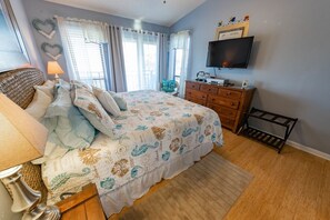 Un dormitorio con cama, cómoda, televisor y adornos.