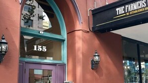 Ein Gebäude mit einer violetten Tür und der Hausnummer 155.