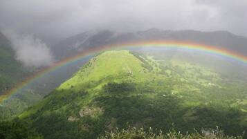 A lush green landscape with a rainbow arching across the sky.