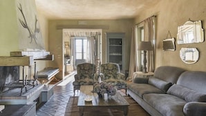 A cozy living room with a fireplace, a sofa, armchairs, and a coffee table. - Verdidea - VILLA AMATO (San Casciano dei Bagni)