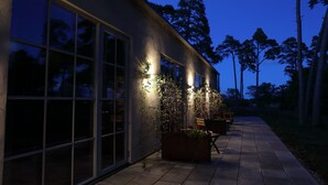 A modern building with large windows and outdoor seating. - Strandakar Hotell & Restaurang (Stånga)