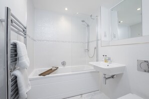 A modern bathroom with a bathtub, shower, and sink. - Elliot Oliver - Luxury 3 Bedroom Town Centre Apartment With Parking (Cheltenham)