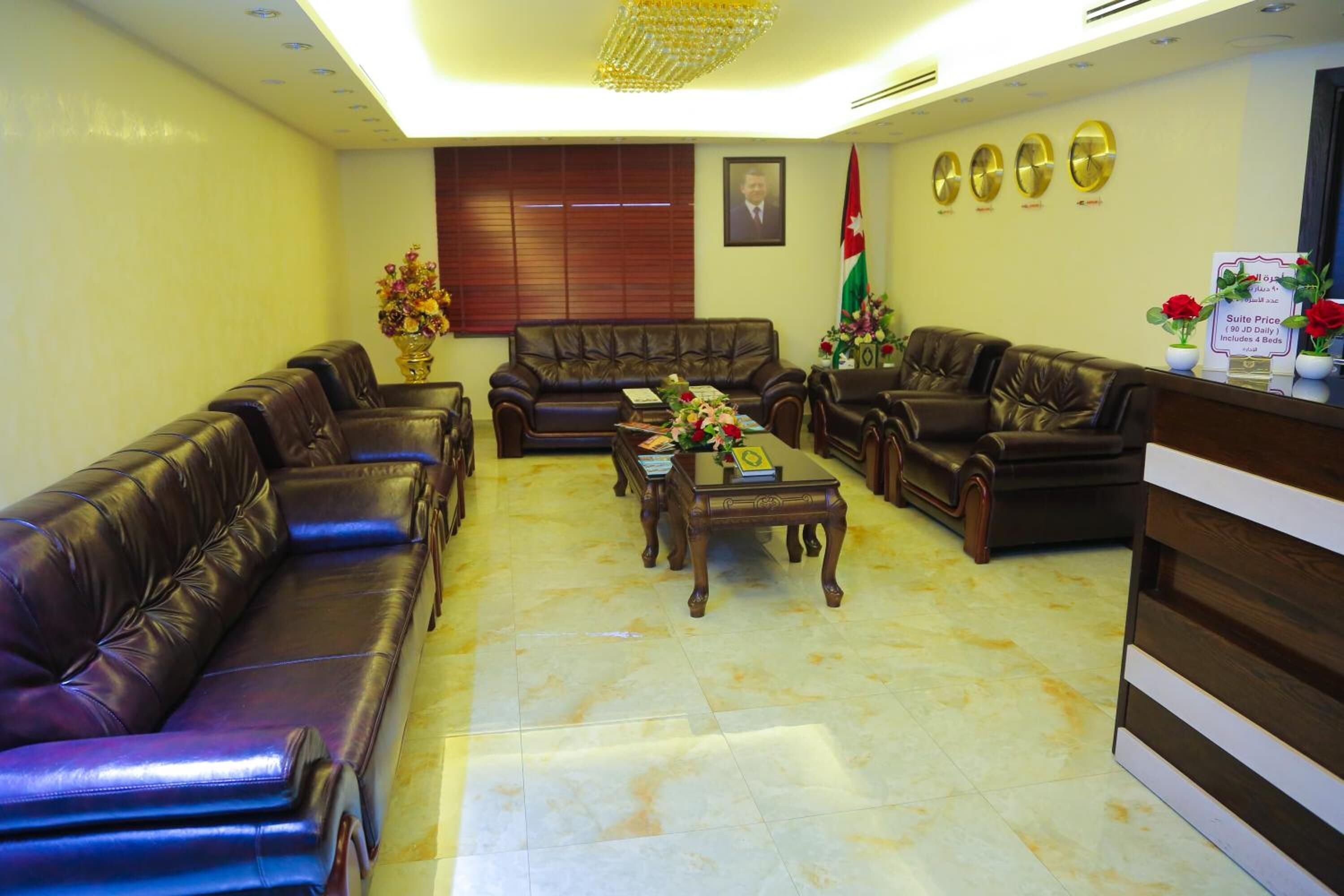 A lobby with leather sofas, a coffee table, and a reception desk.