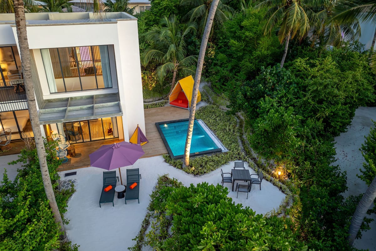 Une villa moderne dotée d’une piscine, d’un espace salon extérieur et d’une végétation luxuriante.