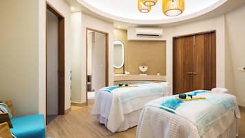 Two beds with crisp linens are positioned in this stylish room, featuring a large mirror and a door leading to another area.