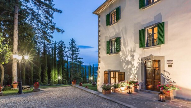 A building with a white facade, green shutters, and a gravel driveway. - Verdidea - PALAZZO DELLE ROSE (Monterchi)