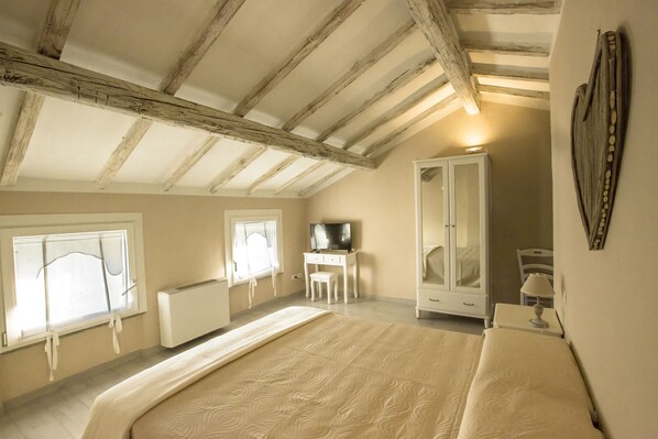 A bedroom with a large bed, a wardrobe, a desk, and a television. - 700 Enolocanda (Santa Giuletta)