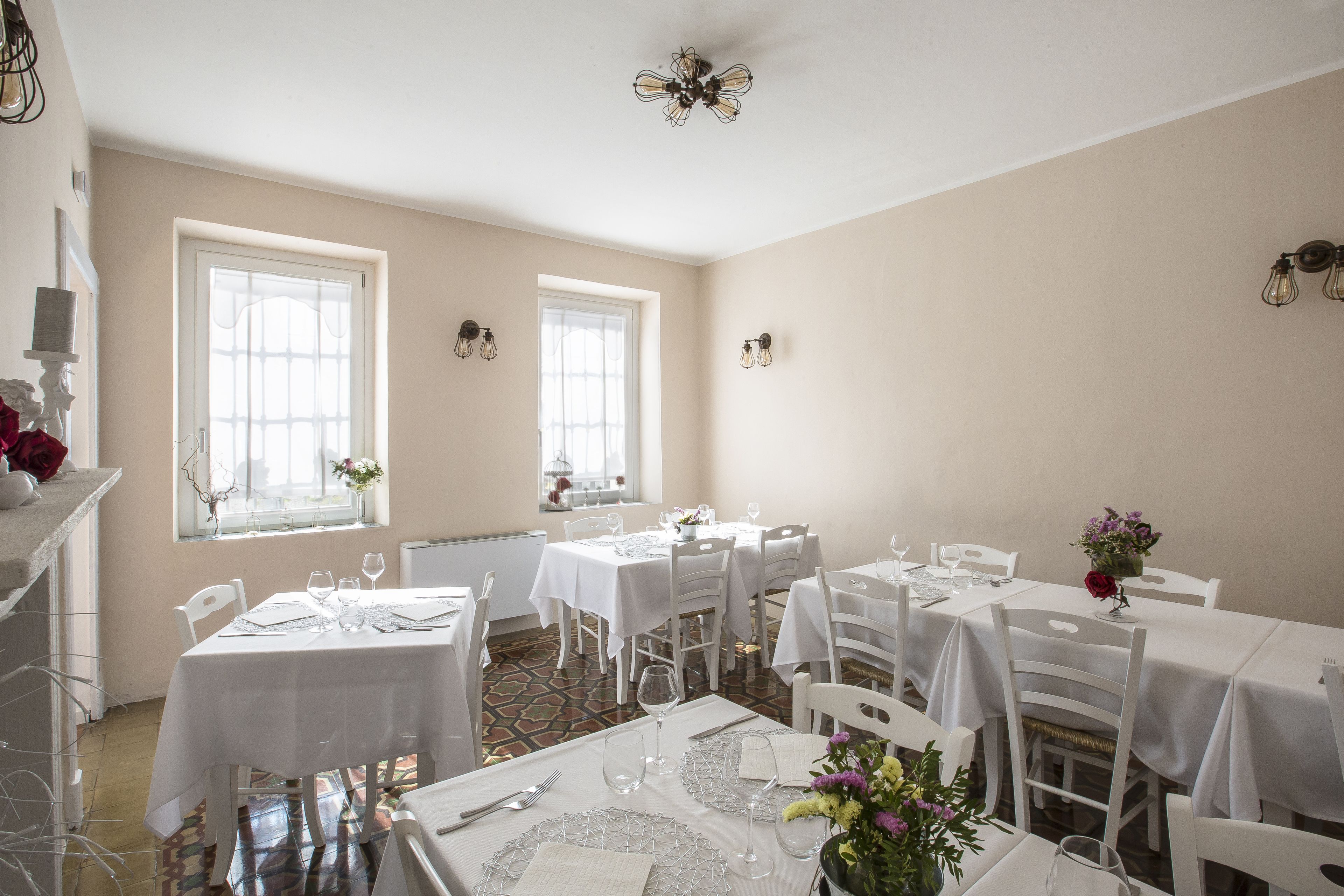 A dining area with multiple tables, chairs, and a chandelier.