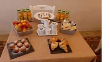 Una mesa con diferentes alimentos, incluyendo frutas, pasteles y bebidas.
