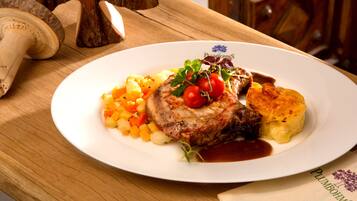 A plate of food with a steak, vegetables, and a side of mashed potatoes.