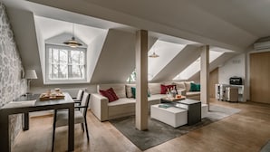 A modern loft-style living space with a dining area, a sofa set, and a small kitchen area. - Dwor DROBLIN (Lesna Podlaska)