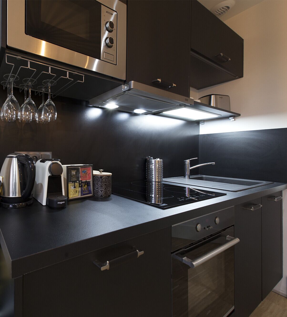 A modern kitchen with a built-in oven, a stovetop, and a microwave.