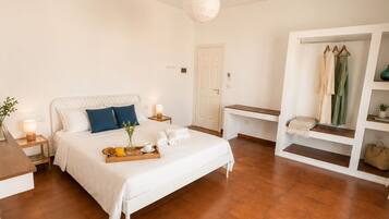 A bedroom with a bed, bedside tables, a wardrobe, and a hanging light fixture.
