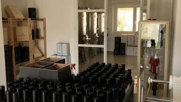 A kitchen area with stainless steel appliances, a wooden shelving unit, and a large number of black and white bottles.