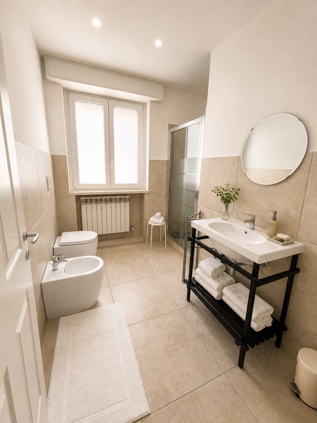 Un baño moderno con inodoro, bidé, lavabo y cabina de ducha de vidrio.