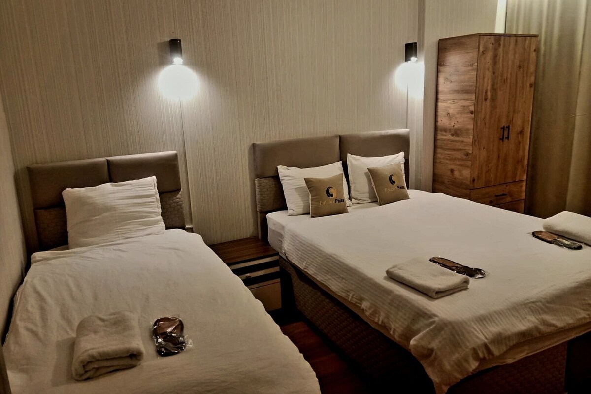 A hotel room with two beds, a wardrobe, and a nightstand.