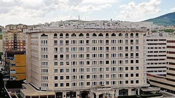 A large, multi-story building with a symmetrical facade, numerous windows, and a central entrance with a covered area.