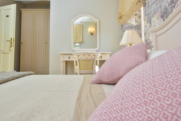 A bedroom with a bed, a vanity with a mirror, a lamp, and a wardrobe. - Hotel Draga di Lovrana (Lovran)