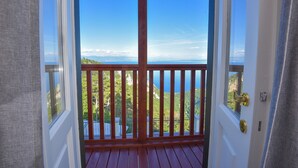 A wooden deck with a metal railing, a clear view of a mountainous landscape, and a door with a brass handle. - Hotel Draga di Lovrana (Lovran)