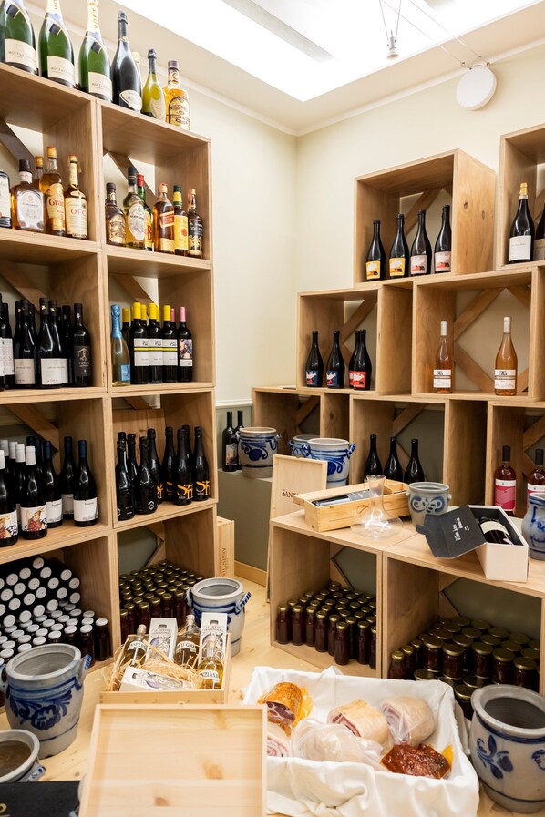 Una bodega con estantes de madera llenos de diversas botellas de vino y licores.