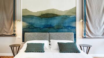 A bed with two pillows, a headboard, and a wall painting.