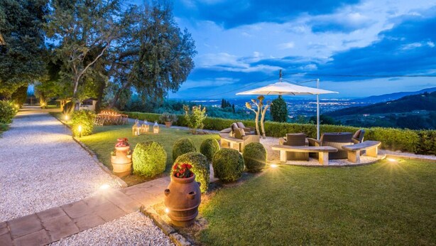 Un área de estar al aire libre bien iluminada, con vistas al paisaje.