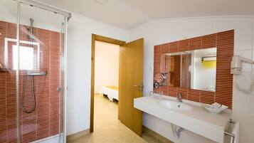 A modern bathroom with a glass shower, a large mirror, and a white sink.