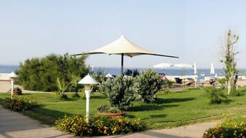 Una passeggiata costiera con una zona relax all'ombra, un percorso e vista sul mare.