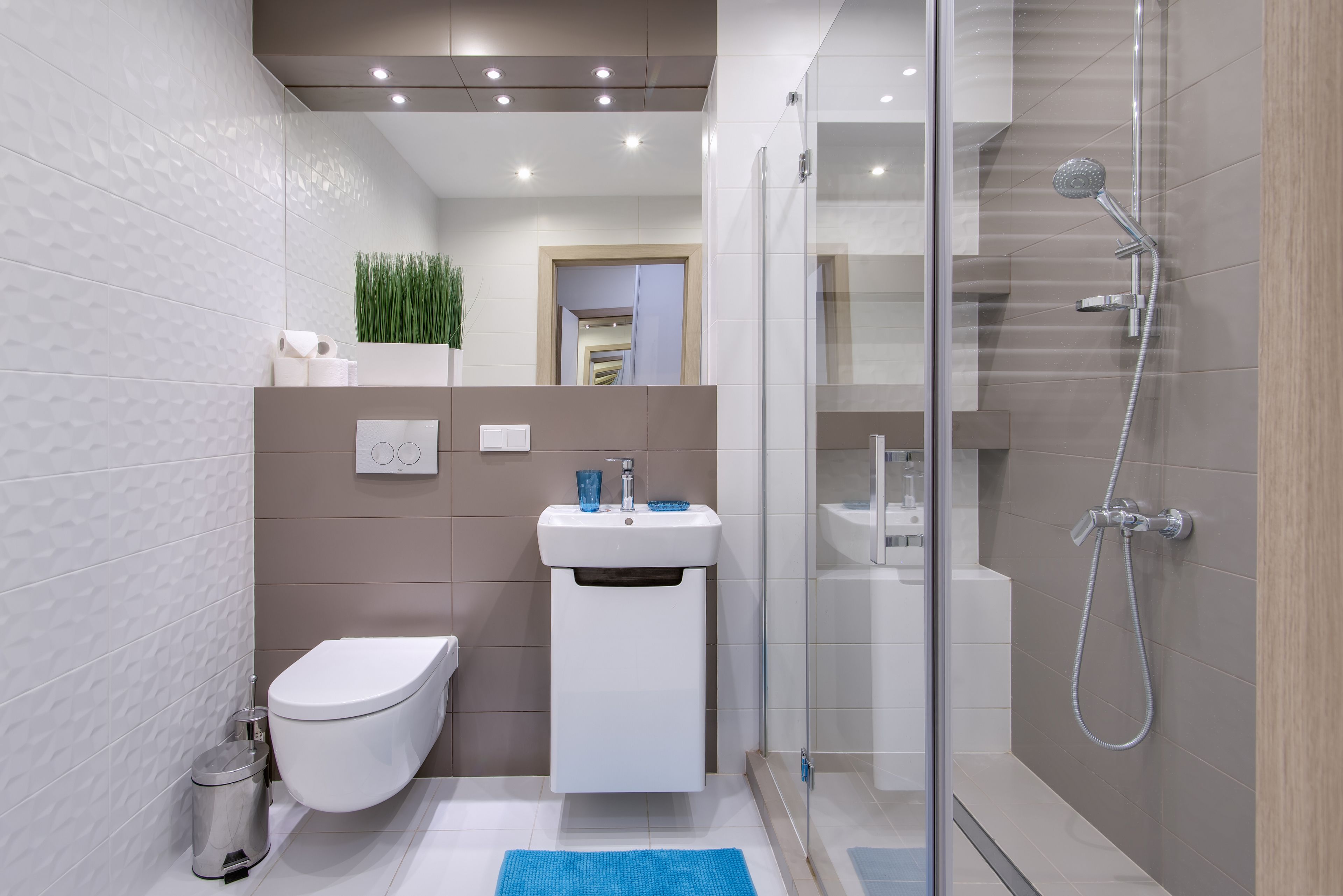 A modern bathroom with a toilet, sink, and shower.