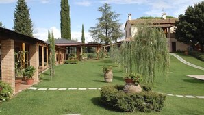 Un jardin bien entretenu, agrémenté d’un bâtiment en briques, d’une pergola et de diverses plantes.