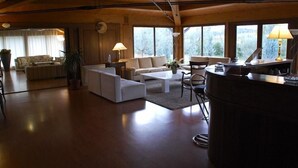 Un salon spacieux au design moderne, comprenant un canapé, une table basse et un coin repas avec un bar.