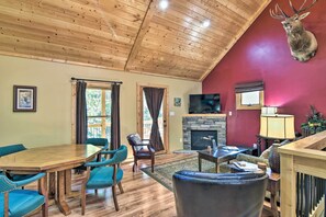 Cozy living room with a high ceiling, fireplace, and comfortable seating options.