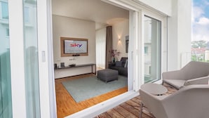 Una sala de estar moderna con un televisor de pantalla plana, un sofá y una terraza de madera.