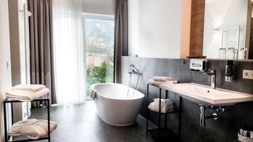 A modern bathroom with a freestanding bathtub, a vanity with a sink, and a large mirror.