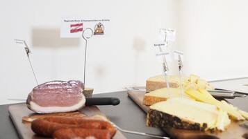 A selection of meats and cheeses on wooden boards with labels indicating their origin.